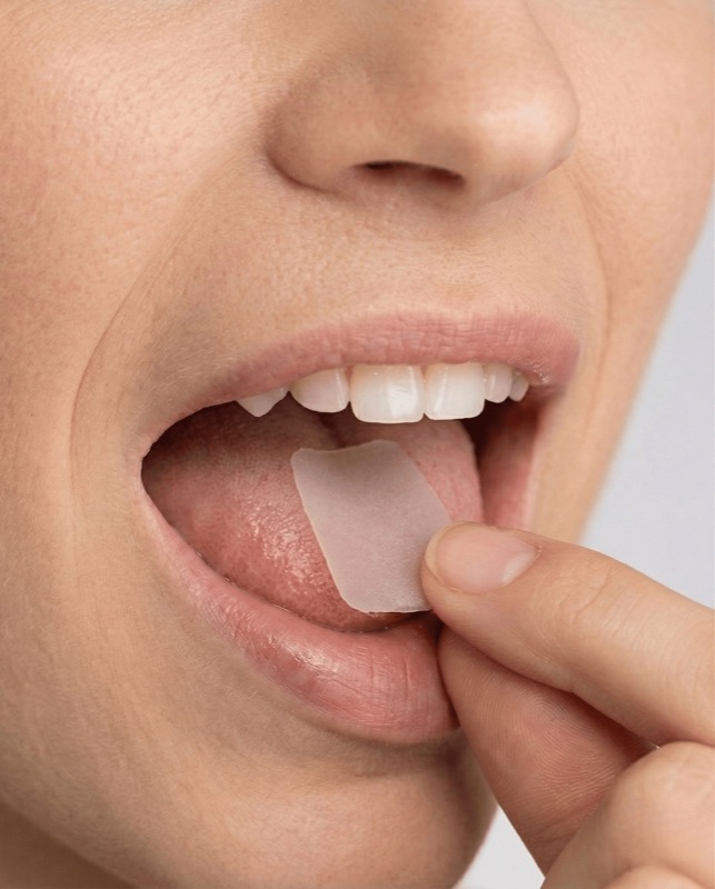 Oral dissolving peptide strip being placed in mouth